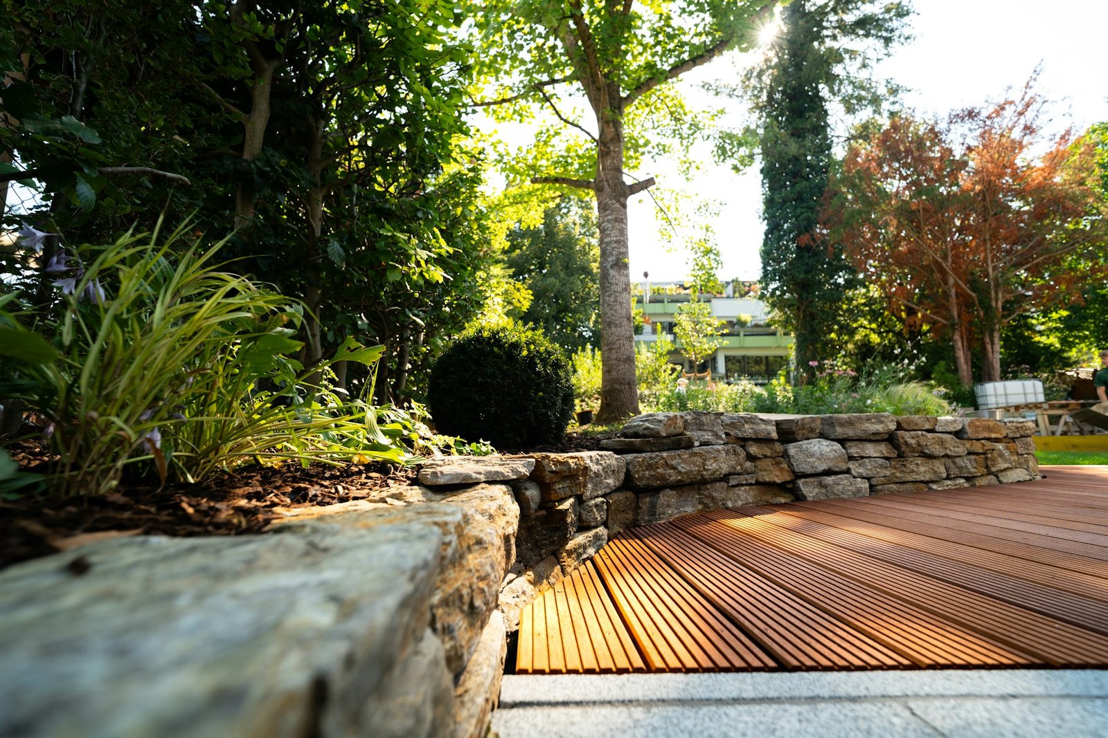 Landscaped garden with stonework and a wooden terrace